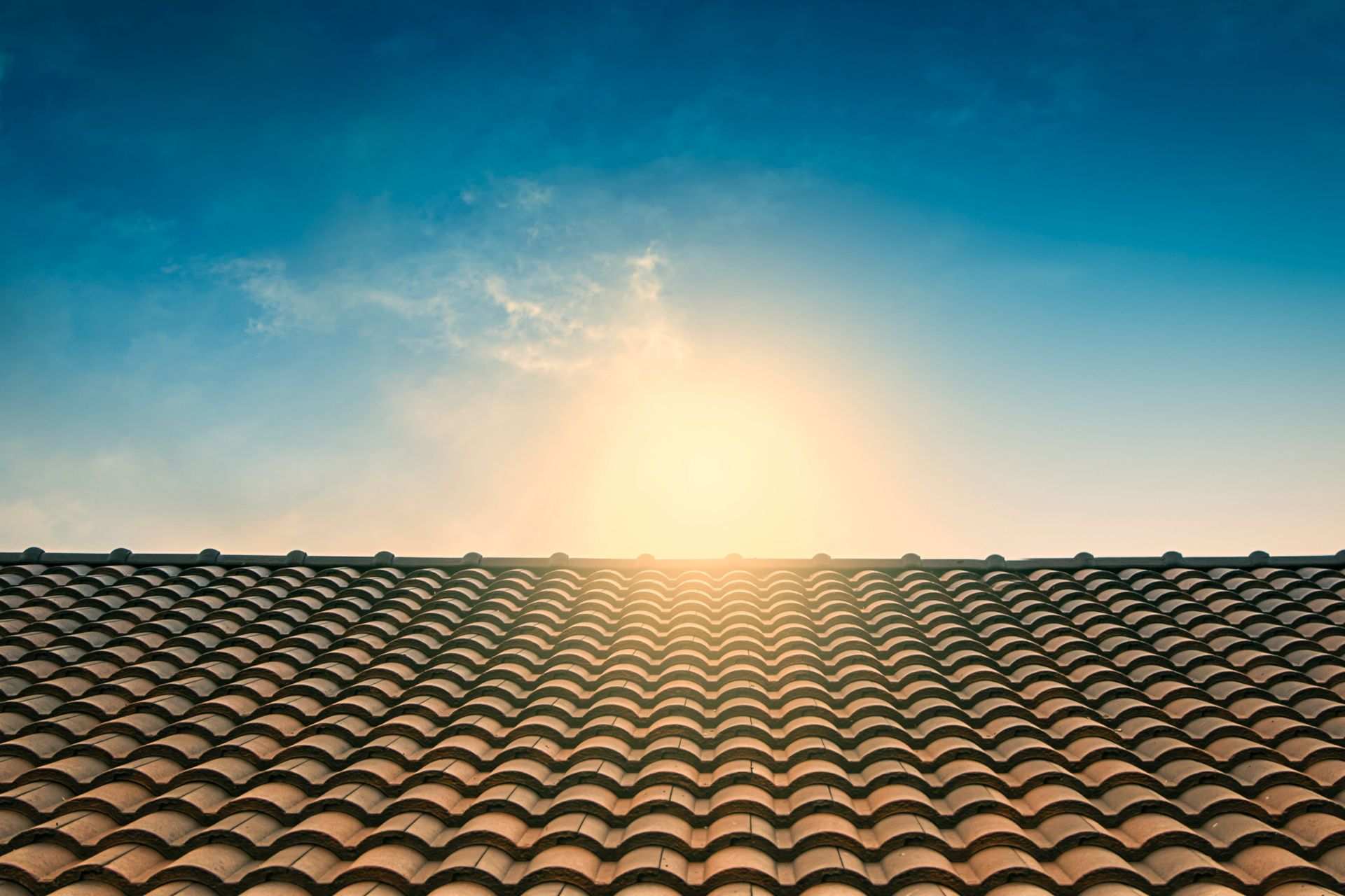 Sun rising over roof of a house